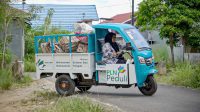 Direktur Bank Sampah Sekumpul Dewi Heldayati menggunakan motor listrik untuk operasional usahanya. | dok. PLN