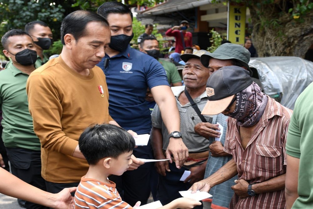 Jokowi dan cucunya, Jan Ethes Srinarendra atau Jan Ethes, membagikan bantuan, sembako, dan kurma kepada para pedagang serta masyarakat yang ada di sekitar pasar. | Biro Pers Sekretariat Presiden
