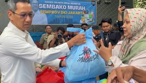 Potret Pj Gubernur DKI Jakarta Heru Budi Hartono membagikan paket sembako menggunakan kantong berwarna biru muda. I X