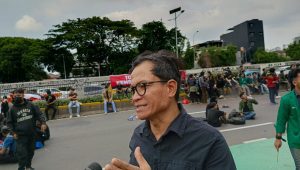 Direktur Eksekutif Amnesty Internasional Indonesia Usman Hamid di depan Gerbang DPR, Kamis, 20/3/2025 | Syahrul Baihari/Forum Keadilan