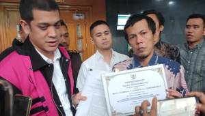 Anak saudagar minyak Mohammad Riza Chalid, Muhammad Kerry Adrianto Riza, menunjukkan dokumen resmi yang menyatakan bahwa PT Orbit Terminal Merak (PT OTM) sebagai Objek Vital Nasional usai sidang dugaan kasus korupsi tata kelola minyak mentah dan produk kilang Pertamina di Pengadilan Tindak Pidana Korupsi (Tipikor) Jakarta, Selasa, 9/12/2025 | Syahrul Baihaqi/Forum Keadilan