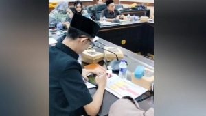 Anggota Komisi D DPRD Jember Achmad Syahri Assidiqi bermain game sambil merokok saat rapat dengar pendapat (RDP) membahas persoalan kesehatan | Ist